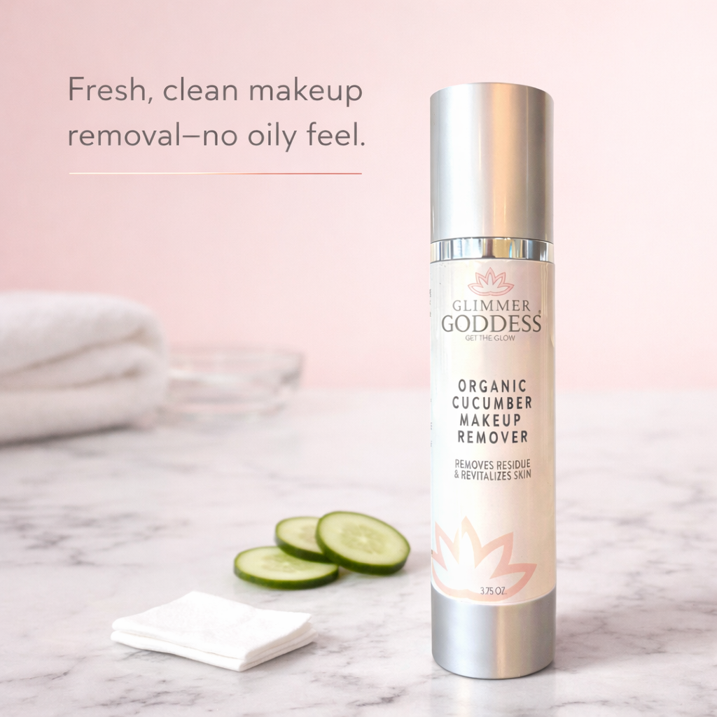 Glimmer Goddess Organic Cucumber Makeup Remover bottle on a pink cotton-candy background in a luxury vanity scene with marble countertop, cucumber slices, and a cotton pad, highlighting fresh makeup removal with no oily residue.