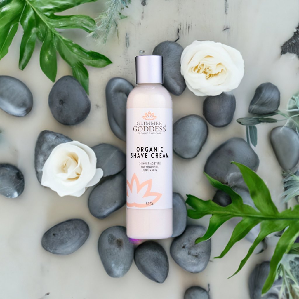 Organic Shave Cream bottle from Glimmer Goddess® surrounded by rocks and flowers