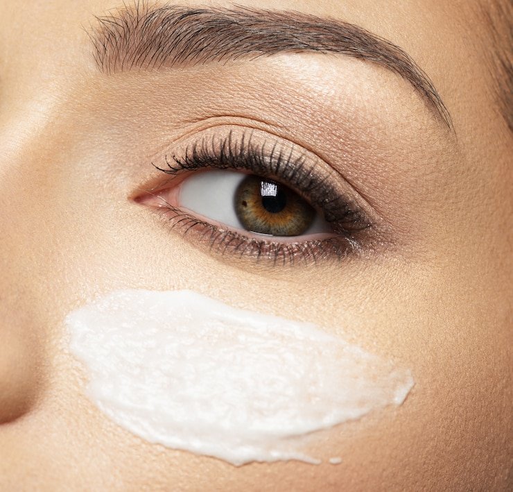 Organic eye cream applied under eye, hydrating skin with vitamins and botanicals for radiant glow