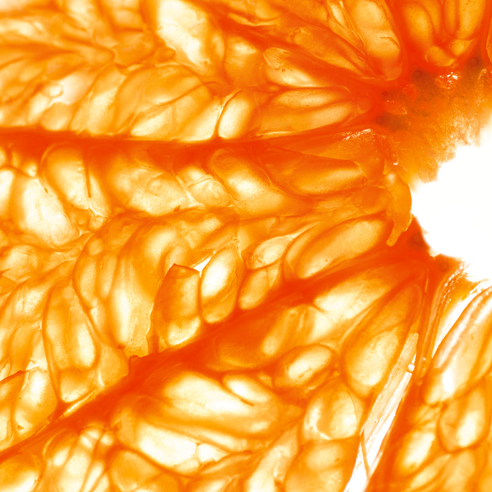 Macro closeup of orange fruit pulp highlighting vibrant, natural botanicals used in skin care