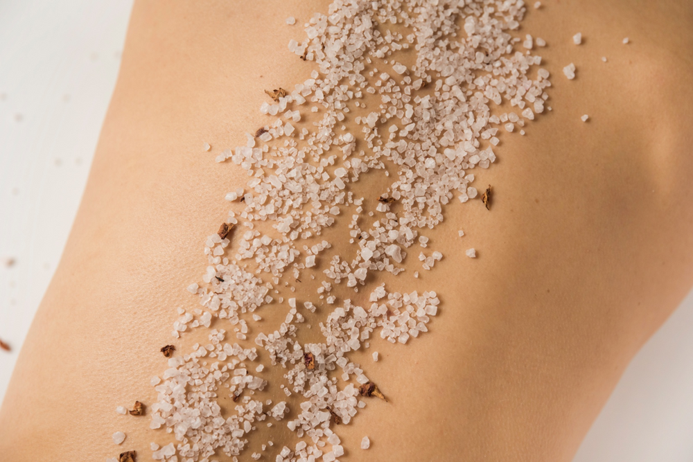 Dead Sea salt crystals on smooth bare back for organic exfoliating skin care
